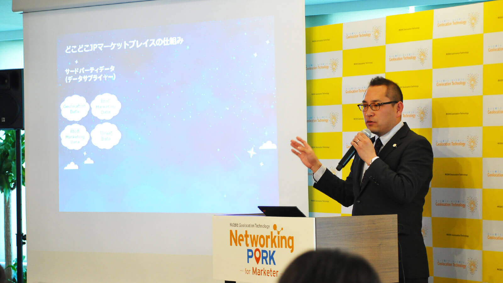 株式会社Geolocation Technology 代表取締役社長（山本敬介）が登壇し、どこどこJPの説明をしている様子